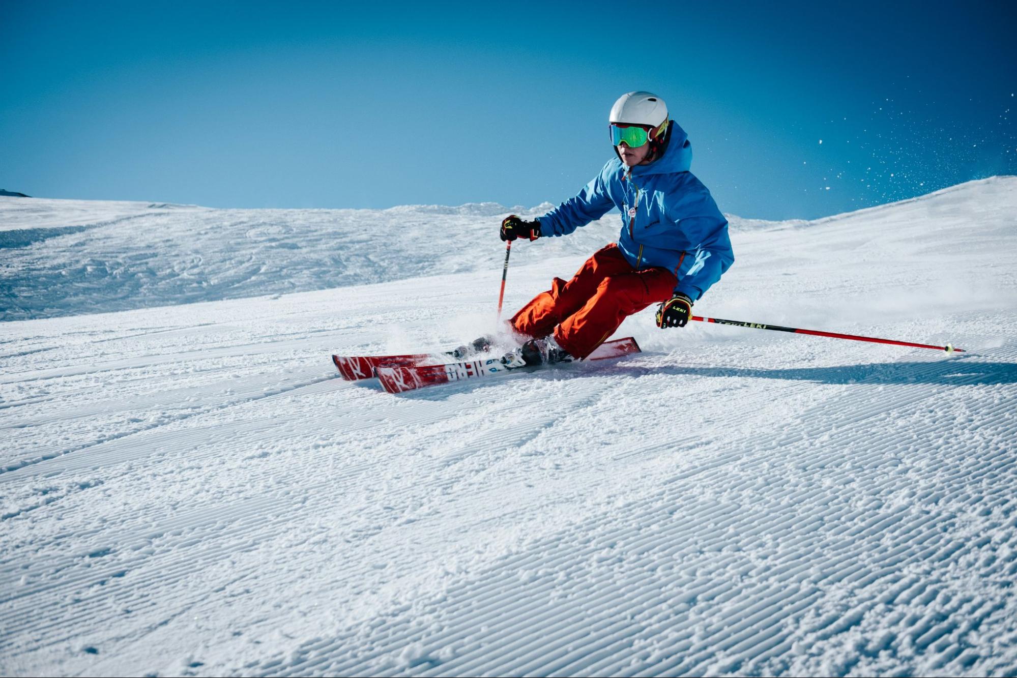 A person with skiing gear skiing down a mountain slope